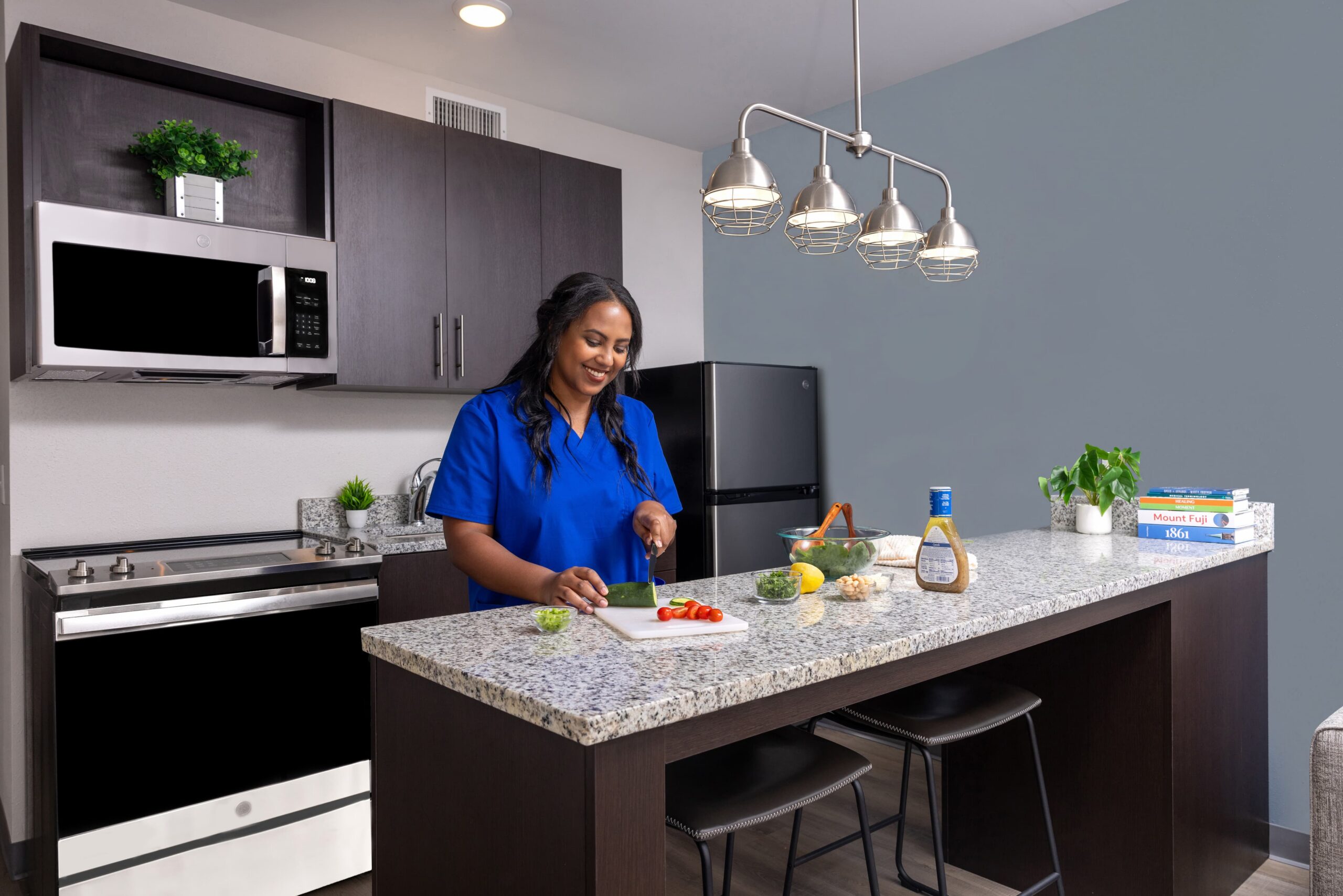 Nurse cooking in stayAPT Suites kitchen