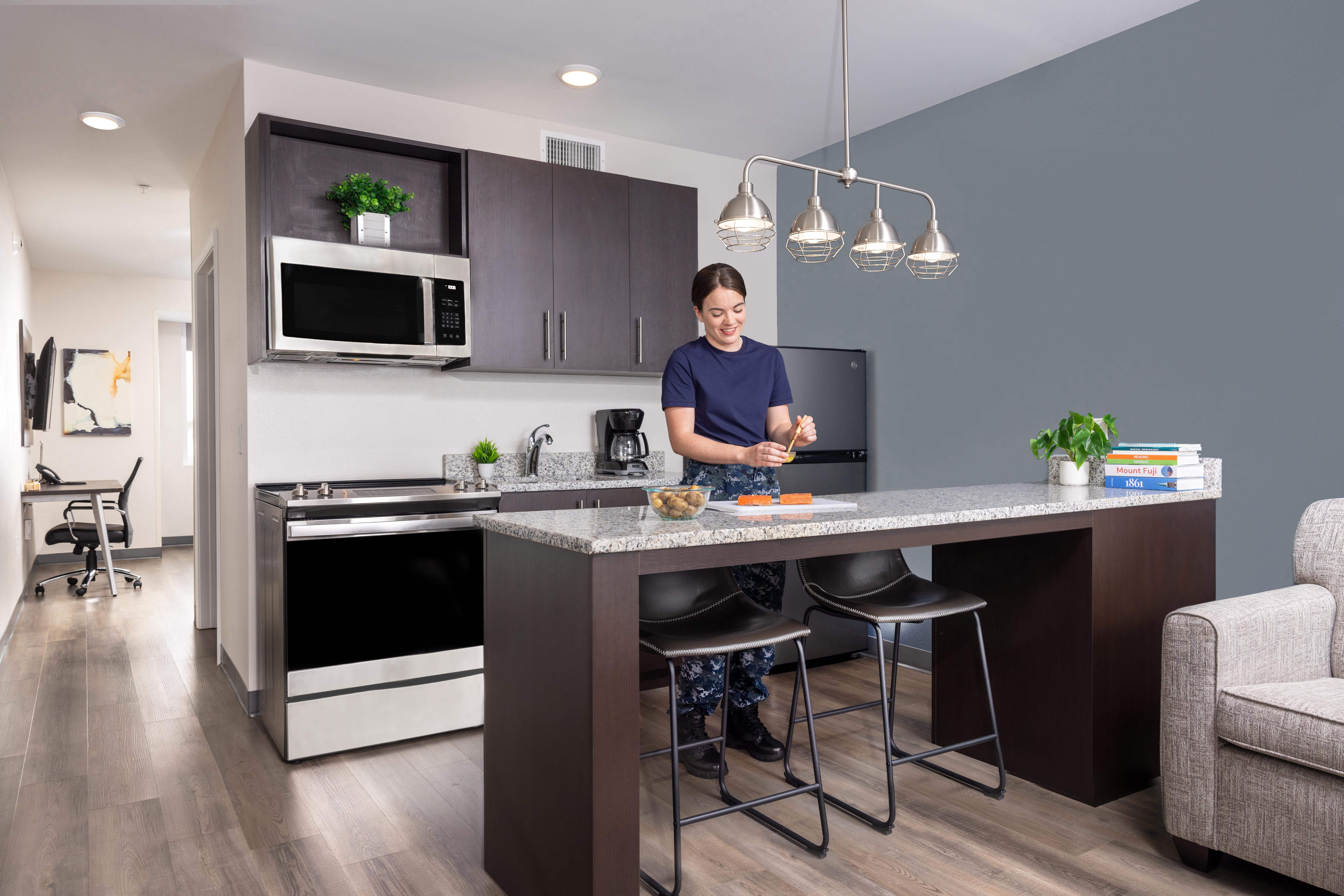 Nurse cooking in stayAPT Suites kitchen